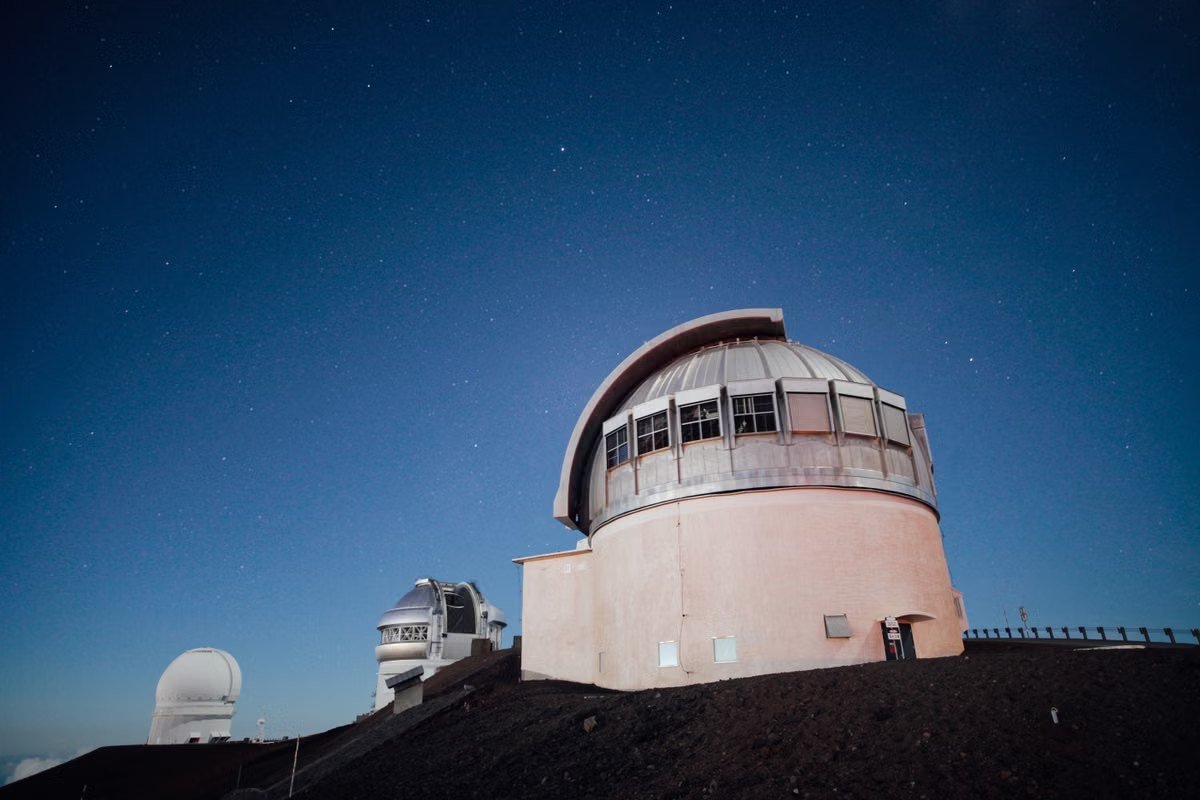 Observatórios astronômicos no alto de uma montanha sob céu estrelado