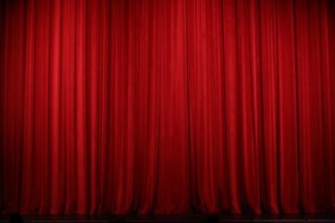 Cortina vermelha de teatro fechada sobre o palco