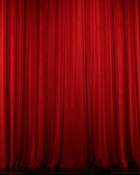 Cortina vermelha de teatro fechada sobre o palco