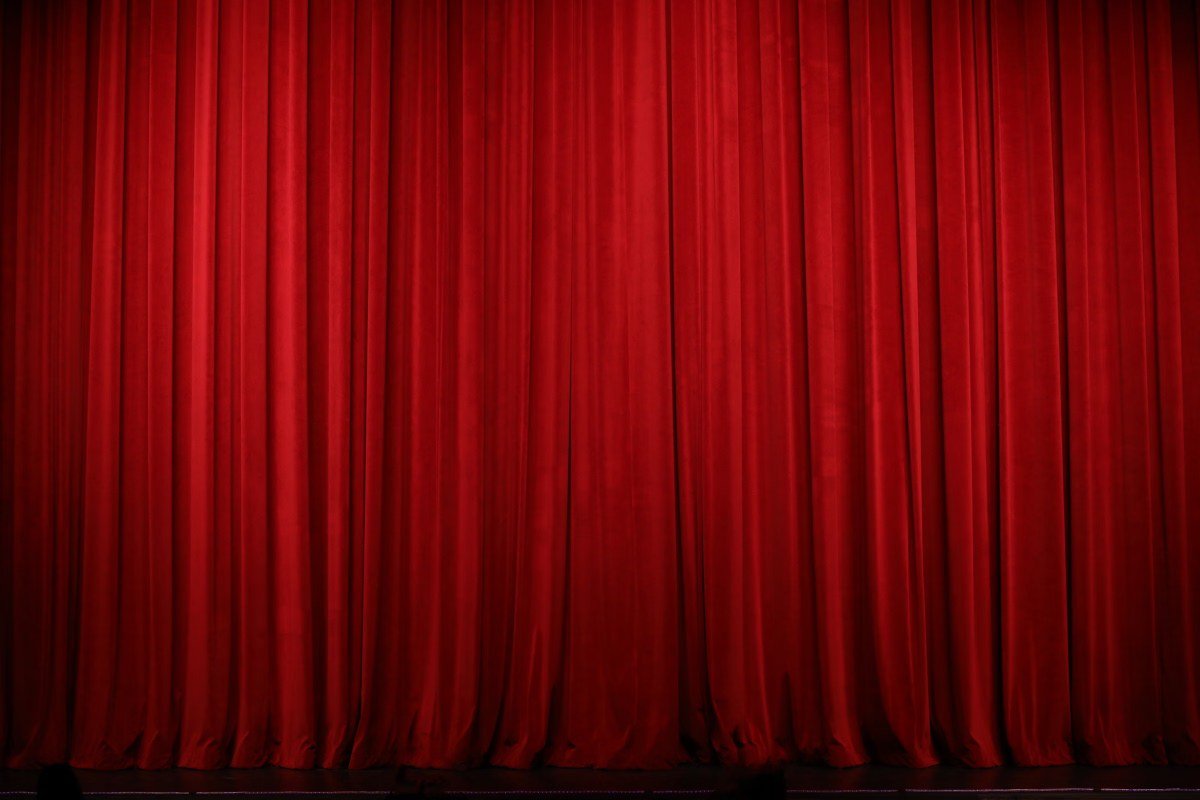 Cortina vermelha de teatro fechada sobre o palco